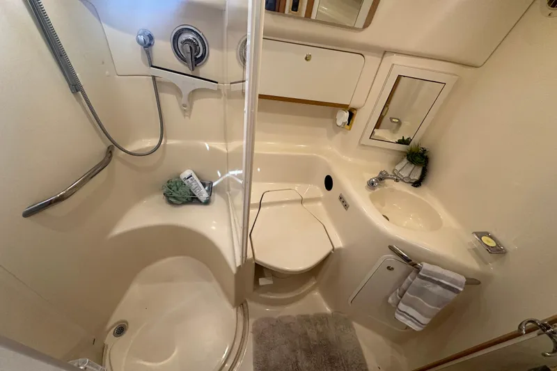 Slide: The Image of 1998 Sea Ray 450 Sundancer bathroom with shower, sink, and storage. - 11