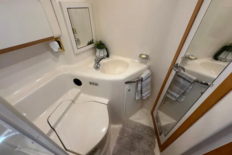 Slide: The Image of 1998 Sea Ray 450 Sundancer bathroom with sink, mirror, and towel rack. - 13
