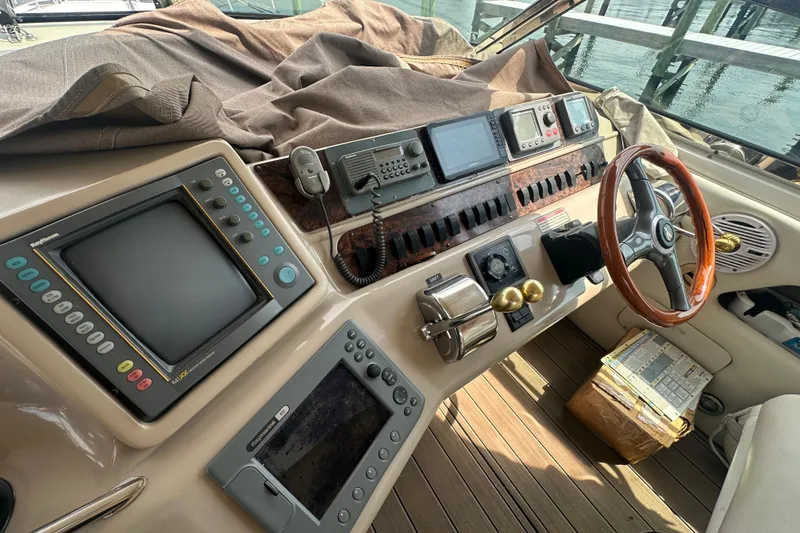 Slide: The Image of 1998 Sea Ray 450 Sundancer helm with navigation equipment and wooden steering wheel. - 19