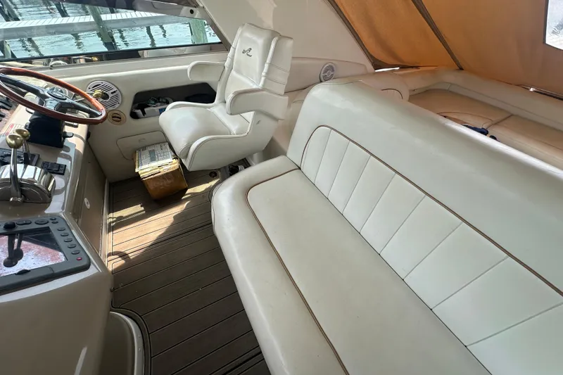 Slide: The Image of Interior of 1998 Sea Ray 450 Sundancer yacht with white seating and wooden accents. - 26
