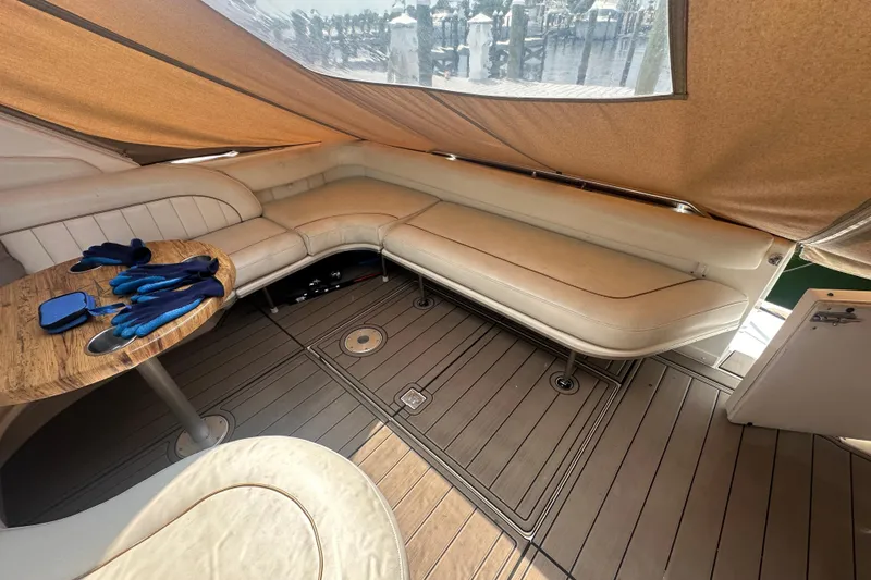 Slide: The Image of Interior of 1998 Sea Ray 450 Sundancer with beige seating and wooden table. - 28
