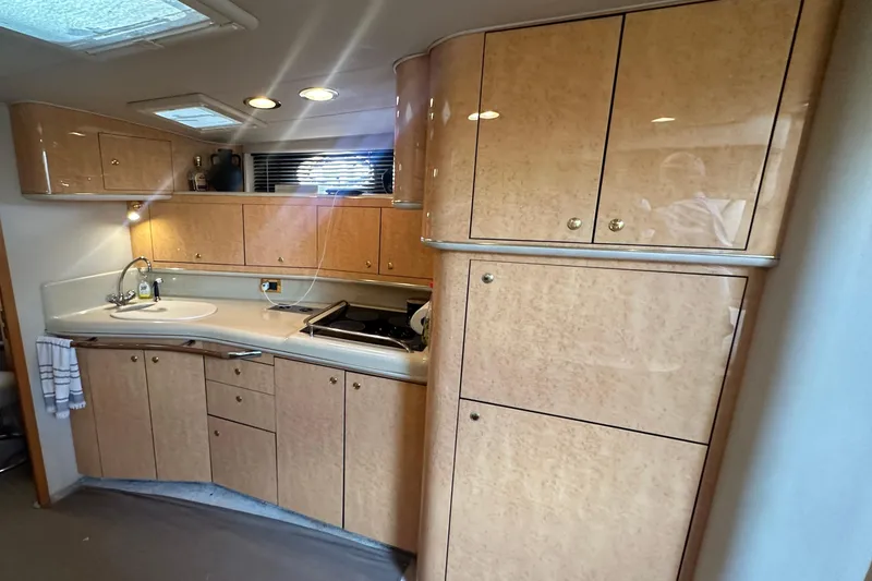 Slide: The Image of Luxurious 1998 Sea Ray 450 Sundancer yacht kitchen with wood cabinetry and modern amenities. - 5