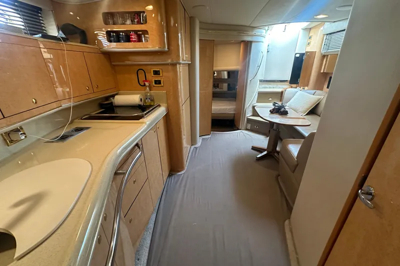 Slide: The Image of Interior of 1998 Sea Ray 450 Sundancer yacht, featuring kitchen and seating area. - 8