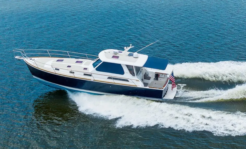 Slide: The Image of 2005 Sabre 42 Express yacht cruising on open water, creating a wake. - 25