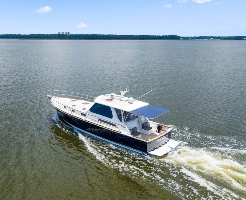 Slide: The Image of 2005 Sabre 42 Express yacht cruising on open water under clear skies. - 27