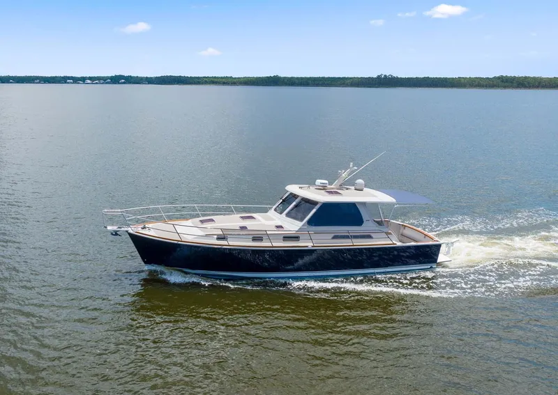 Slide: The Image of 2005 Sabre 42 Express yacht cruising on calm waters under a clear sky. - 31