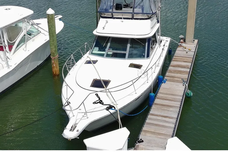 The Image of 1989 Tiara Yachts 3100 Flybridge docked at marina, aerial view. - 1