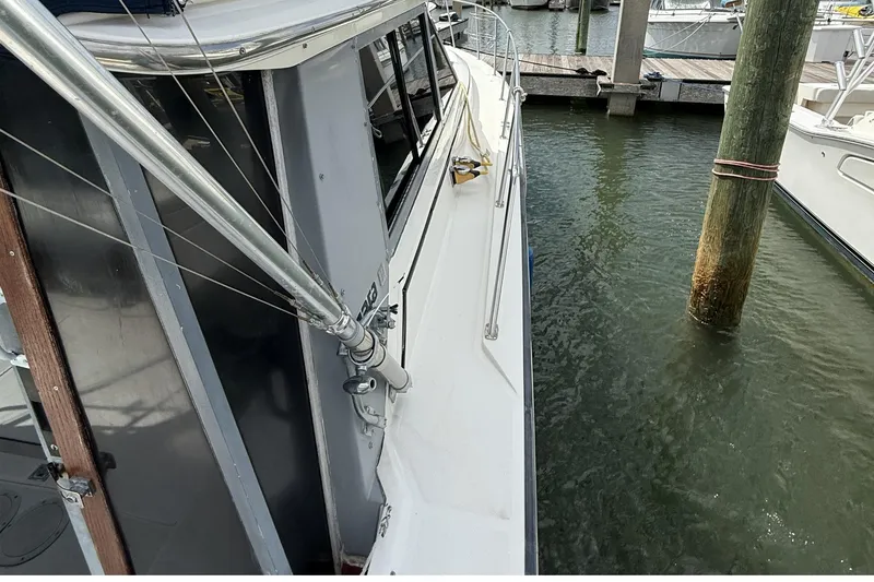 Slide: The Image of 1989 Tiara Yachts 3100 Flybridge docked, showcasing side view and marina setting. - 10