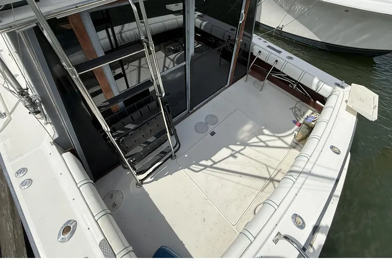 Slide: The Image of 1989 Tiara Yachts 3100 Flybridge boat deck with ladder and seating area. - 11
