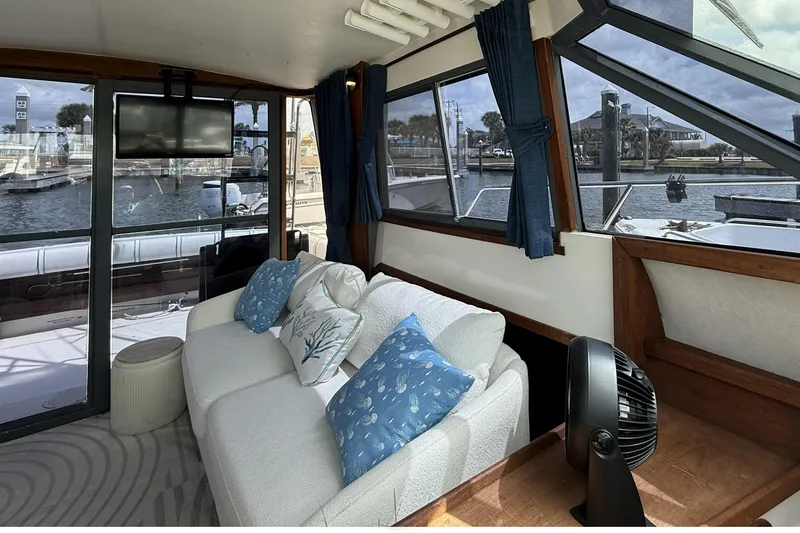 Slide: The Image of Interior of 1989 Tiara Yachts 3100 Flybridge with cozy seating and marina view. - 15