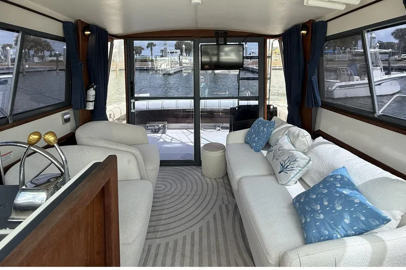 Slide: The Image of Interior of 1989 Tiara Yachts 3100 Flybridge with cozy seating and marina view. - 16