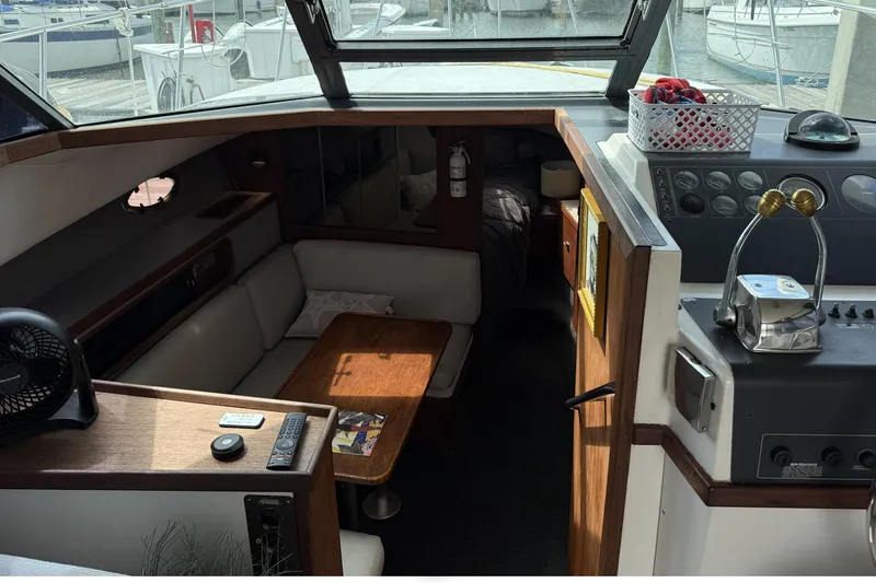 Slide: The Image of 1989 Tiara Yachts 3100 Flybridge interior with seating, table, and control panel. - 19