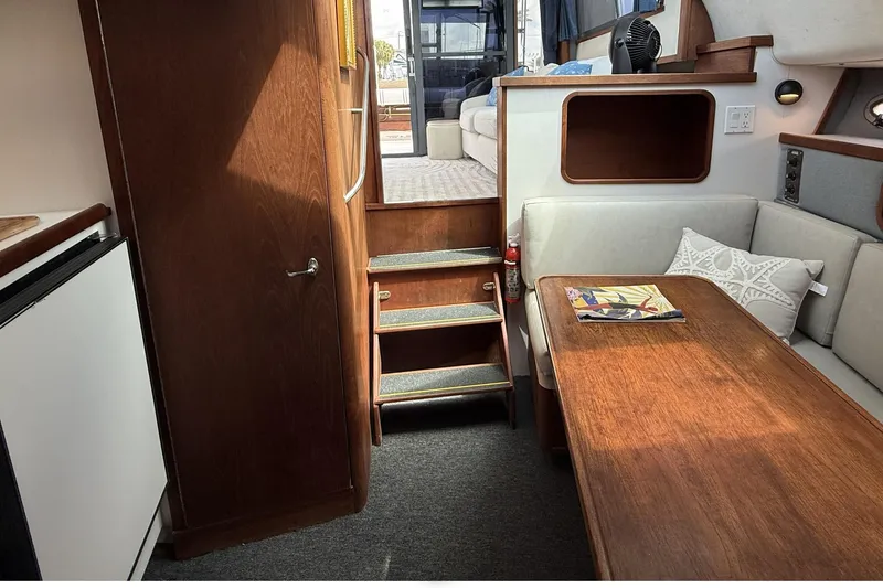 Slide: The Image of Interior of 1989 Tiara Yachts 3100 Flybridge, featuring cozy seating and wooden table. - 21