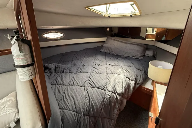 Slide: The Image of Cozy cabin interior of 1989 Tiara Yachts 3100 Flybridge with bed and porthole. - 25