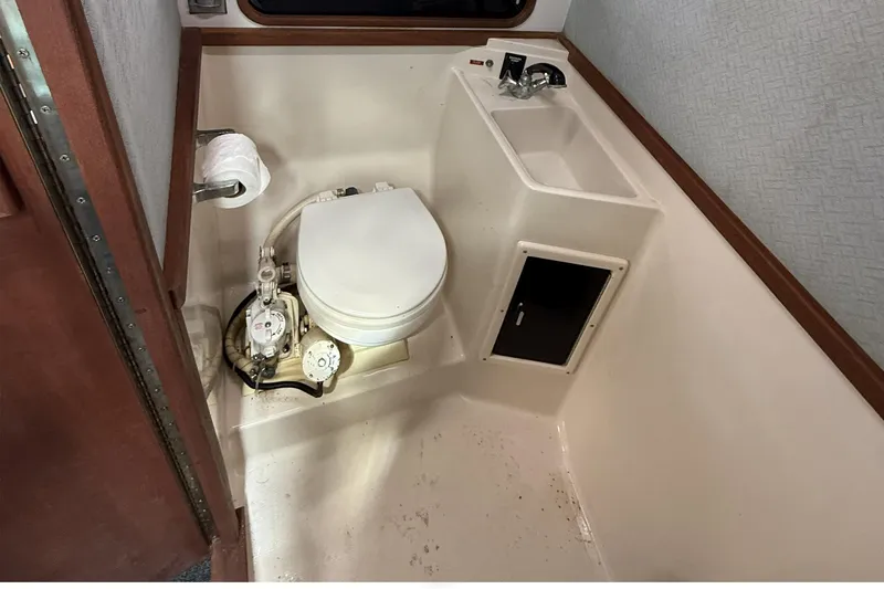 Slide: The Image of 1989 Tiara Yachts 3100 Flybridge bathroom with toilet, sink, and storage compartment. - 27