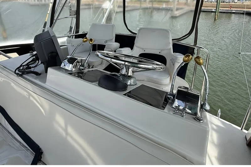 Slide: The Image of 1989 Tiara Yachts 3100 Flybridge helm with steering wheel and controls. - 28