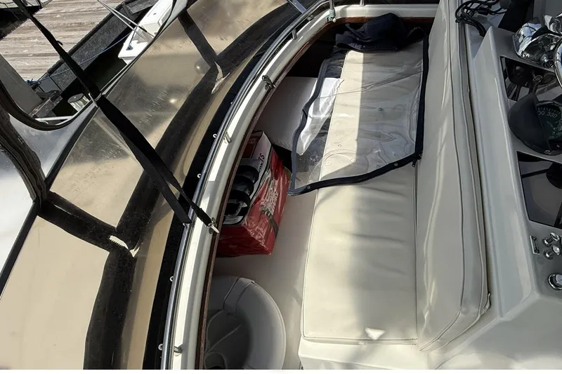 Slide: The Image of 1989 Tiara Yachts 3100 Flybridge interior with white seating and navigation equipment. - 30