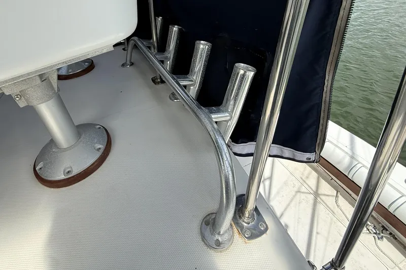 Slide: The Image of 1989 Tiara Yachts 3100 Flybridge deck with metal railings and rod holders. - 35