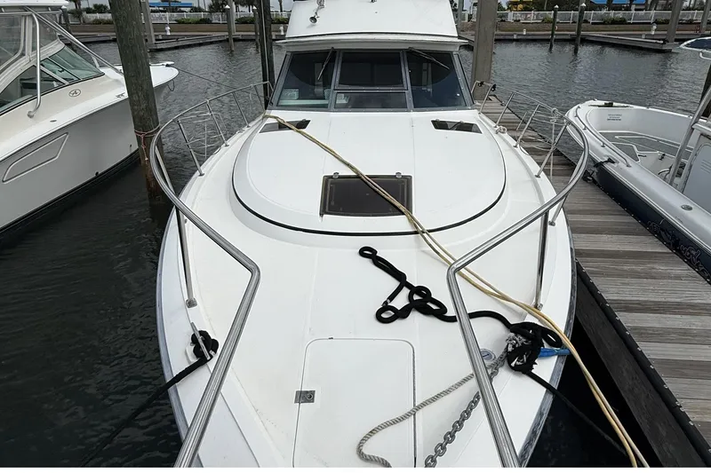 Slide: The Image of 1989 Tiara Yachts 3100 Flybridge docked, showcasing sleek design and spacious deck. - 5