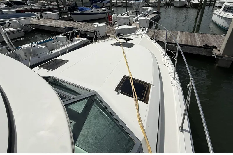 Slide: The Image of 1989 Tiara Yachts 3100 Flybridge docked at marina, showcasing sleek deck design. - 8