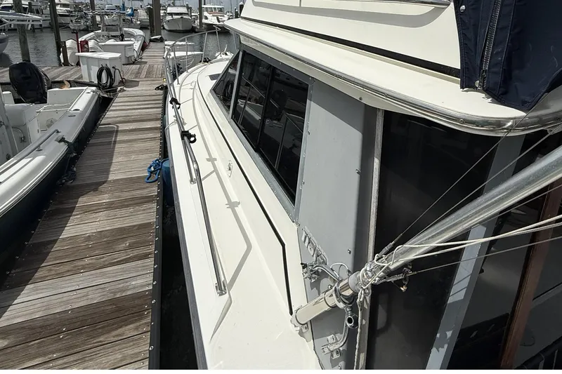 Slide: The Image of 1989 Tiara Yachts 3100 Flybridge docked at marina, showcasing sleek design and spacious deck. - 9