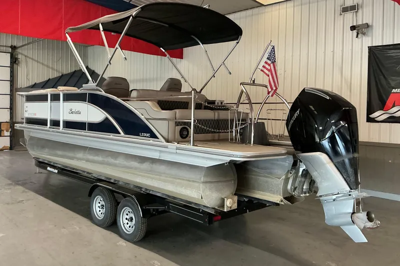 Slide: The Image of 2021 Barletta L23UC pontoon boat with canopy and outboard motor in a garage. - 16