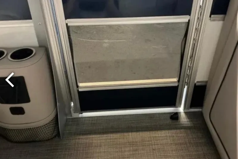 Slide: The Image of Interior of a 2021 Barletta L23UC pontoon boat, featuring a door and cup holders. - 22