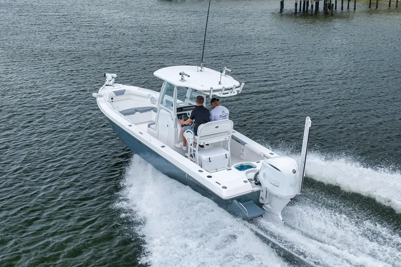 Slide: The Image of 2018 Everglades 243 Center Console boat cruising on water with two passengers. - 29