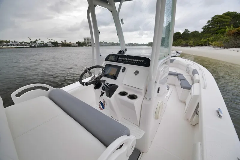 Slide: The Image of 2018 Everglades 243 Center Console boat interior near a sandy shore. - 40