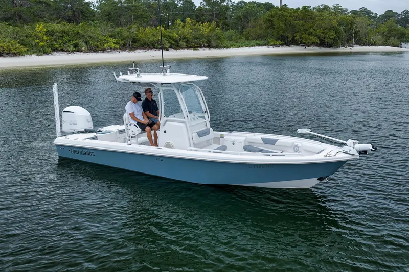 Slide: The Image of 2018 Everglades 243 Center Console boat on calm water near a sandy shoreline. - 6