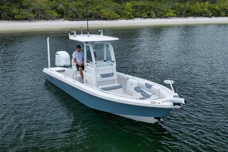 Slide: The Image of 2018 Everglades 243 Center Console boat on calm water near a sandy shore. - 7