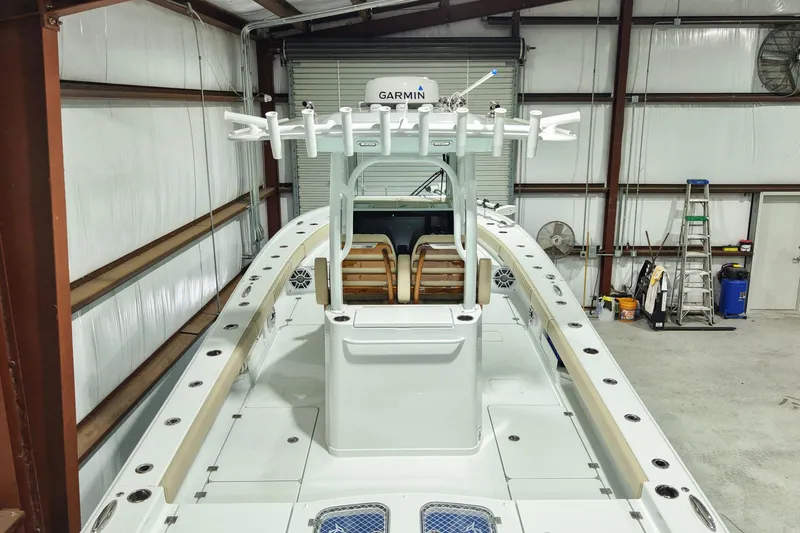 Slide: The Image of 2024 Freeman 28 boat in a garage, featuring a Garmin system and fishing rod holders. - 12