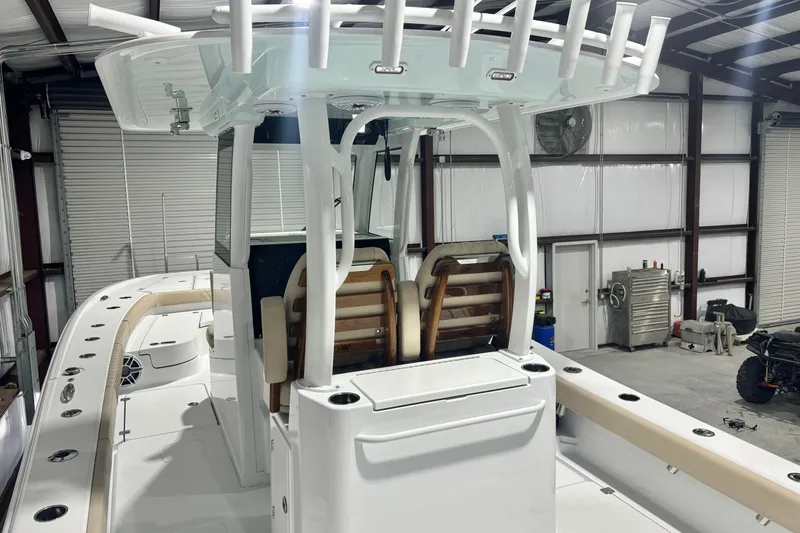 Slide: The Image of 2024 Freeman 28 boat interior in a warehouse, featuring seating and rod holders. - 14