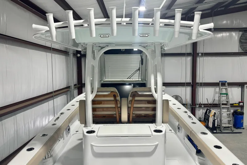 Slide: The Image of 2024 Freeman 28 boat interior in a warehouse, featuring rod holders and seating. - 15