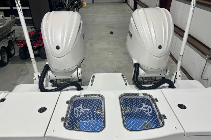 Slide: The Image of 2024 Freeman 28 boat with dual outboard engines in a garage setting. - 22