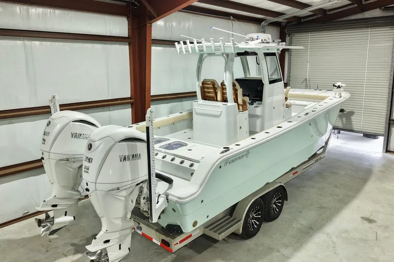 Slide: The Image of 2024 Freeman 28 boat with twin Yamaha engines in a garage. - 3