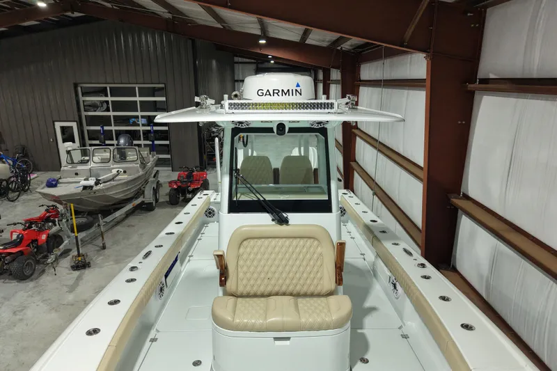 Slide: The Image of 2024 Freeman 28 boat in a garage with Garmin equipment, surrounded by ATVs and another boat. - 9