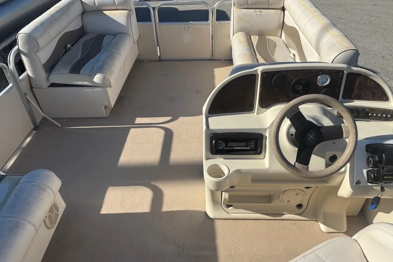 Slide: The Image of Interior of a 2007 Sweetwater 1880 C pontoon boat with beige seating and steering console. - 6