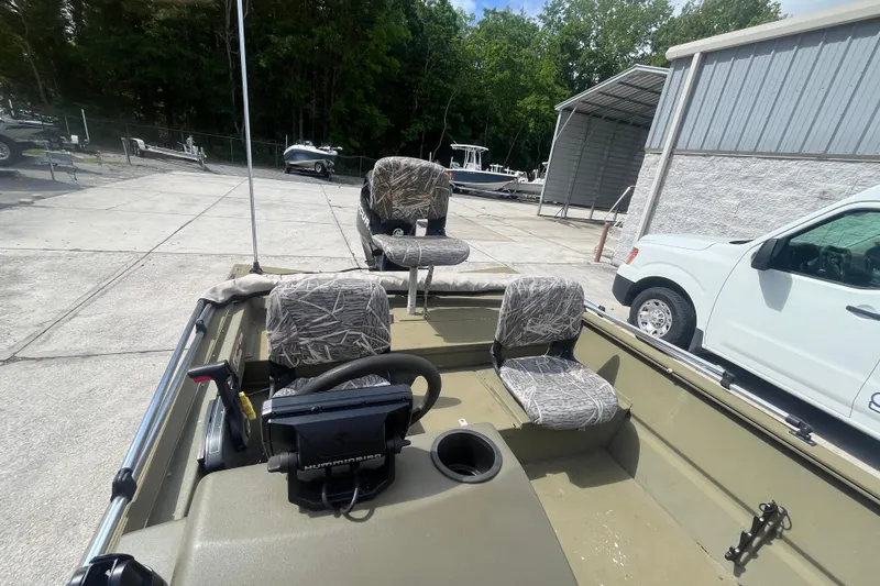 Slide: The Image of 2011 Tracker Grizzly 1754 Side Console boat with camo seats, parked outdoors. - 12