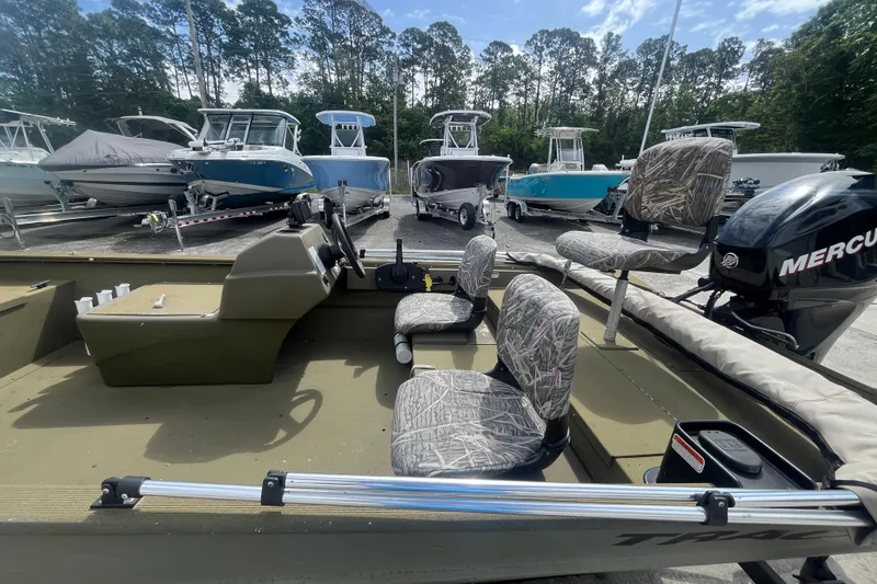 Slide: The Image of 2011 Tracker Grizzly 1754 Side Console boat with camo seats and Mercury outboard motor. - 14
