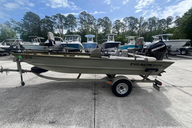 Slide: The Image of 2011 Tracker Grizzly 1754 Side Console boat on trailer, parked outdoors. - 5