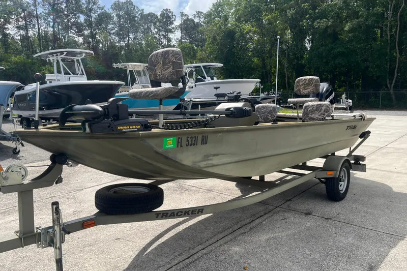 Slide: The Image of 2011 Tracker Grizzly 1754 Side Console boat on trailer, parked outdoors. - 6