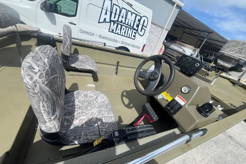 Slide: The Image of 2011 Tracker Grizzly 1754 Side Console boat interior with camo seats and steering wheel. - 9