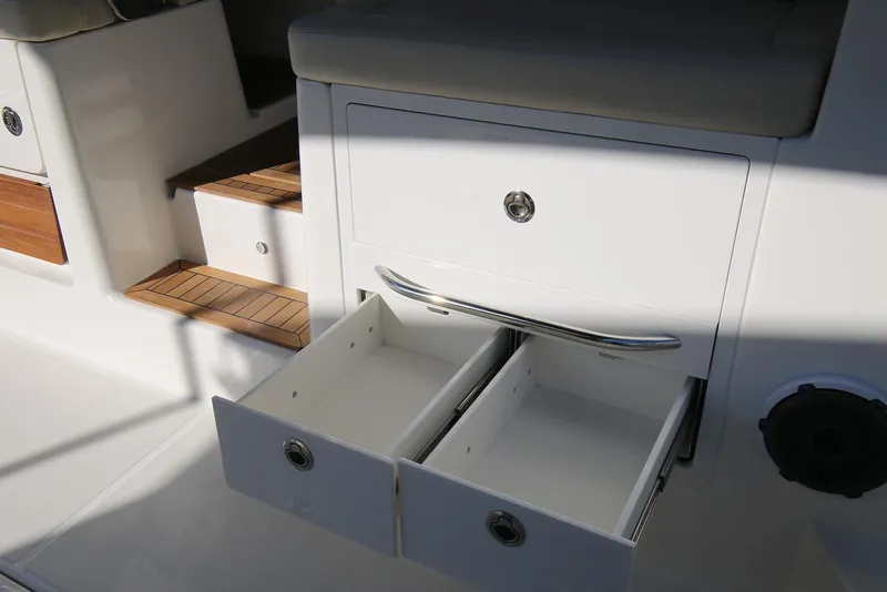 Slide: The Image of Manufacturer Provided Image: 2026 Boston Whaler 405 Conquest interior with open storage drawers and wooden steps. - 11