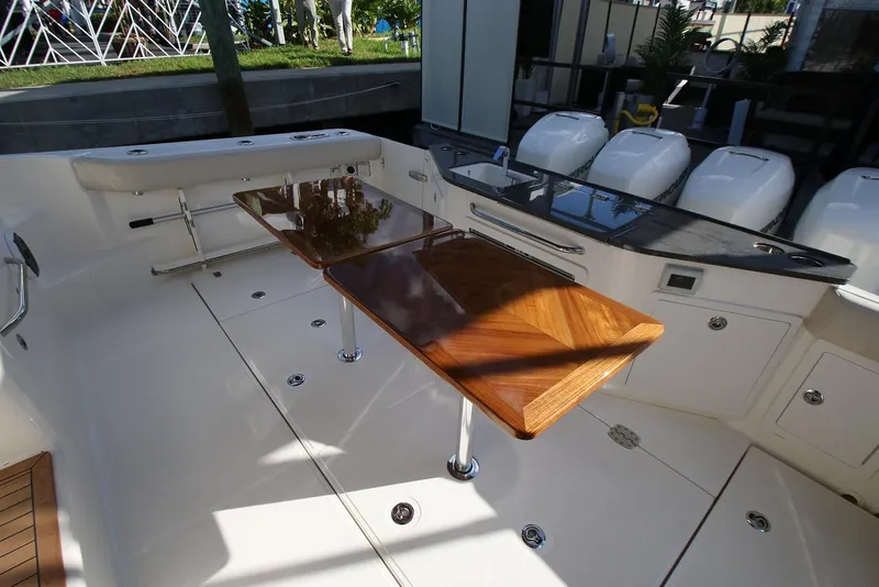 Slide: The Image of Manufacturer Provided Image: 2026 Boston Whaler 405 Conquest boat interior with wooden table and seating area. - 9