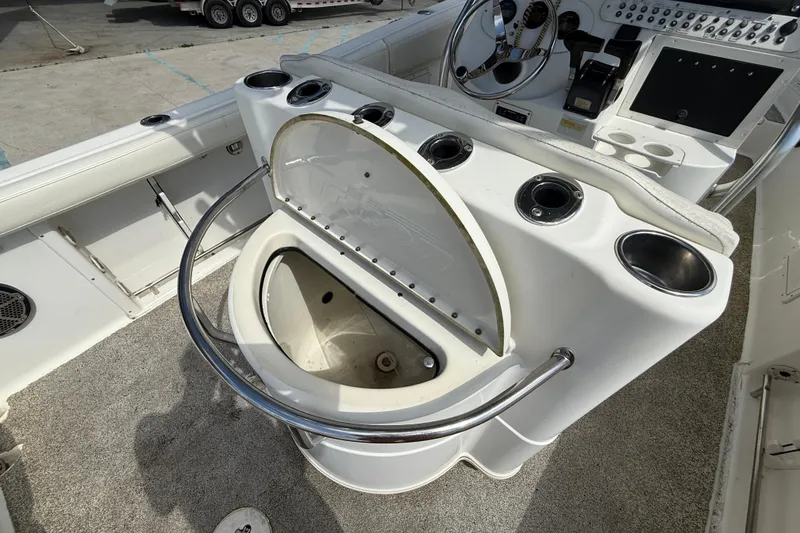 Slide: The Image of 2006 Triton 2690 CC boat console with open storage compartment and steering wheel. - 12