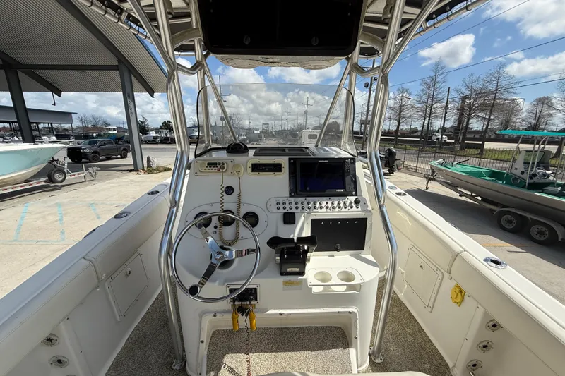 Slide: The Image of 2006 Triton 2690 CC boat console with steering wheel and navigation equipment. - 13