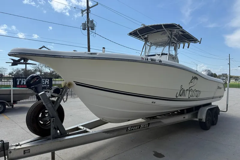 Slide: The Image of 2006 Triton 2690 CC boat on trailer, side view, clear sky background. - 3