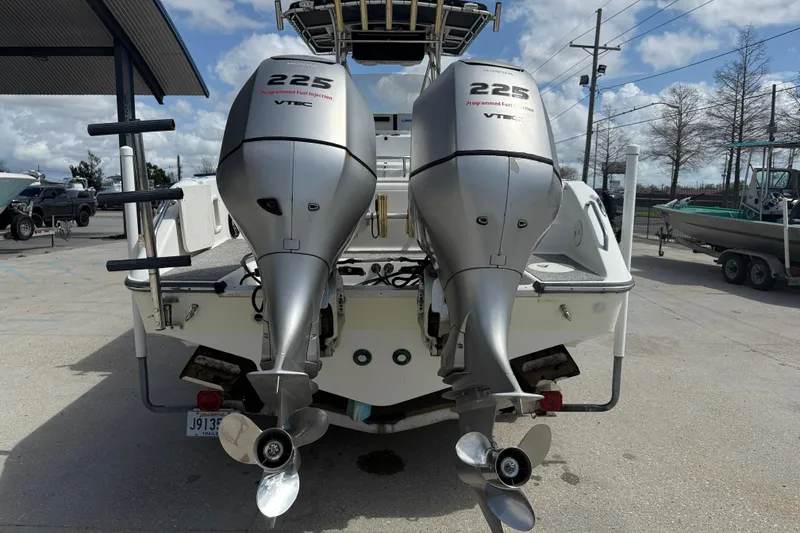 Slide: The Image of 2006 Triton 2690 CC boat with dual 225 horsepower outboard engines at a marina. - 5