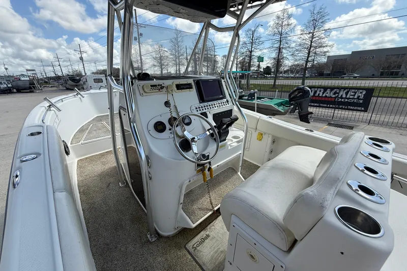 Slide: The Image of 2006 Triton 2690 CC boat interior with steering console and seating. - 8